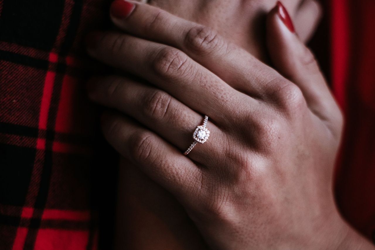 Mysterious lady wearing an extraordinary engagement ring with a square halo setting and a pave sidestone accent