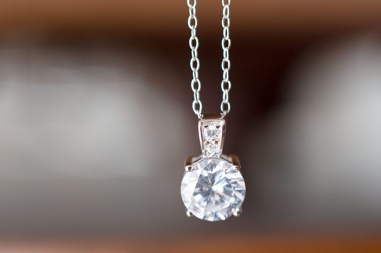 A close-up of a white gold solitaire diamond necklace